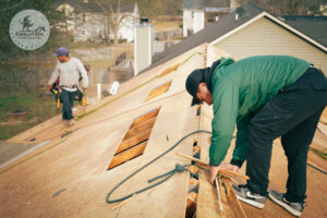 A project manager helps a roofing crew prepare to begin installing underlayment