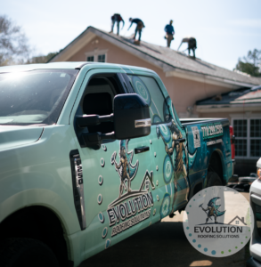 A roofer's truck is parked in front of a home as a brand new roof is being installed
