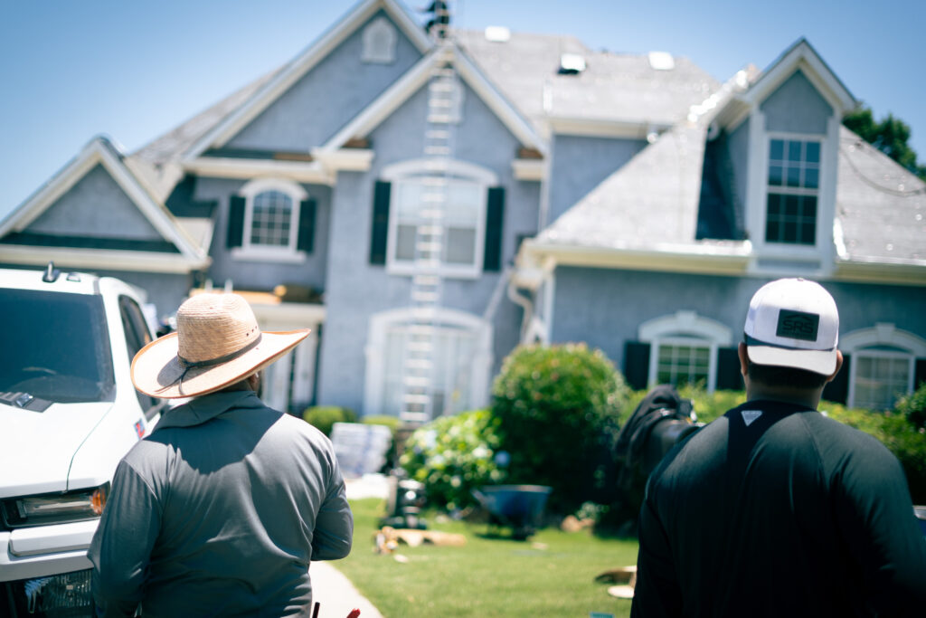 A project manager stands in front of a roof install